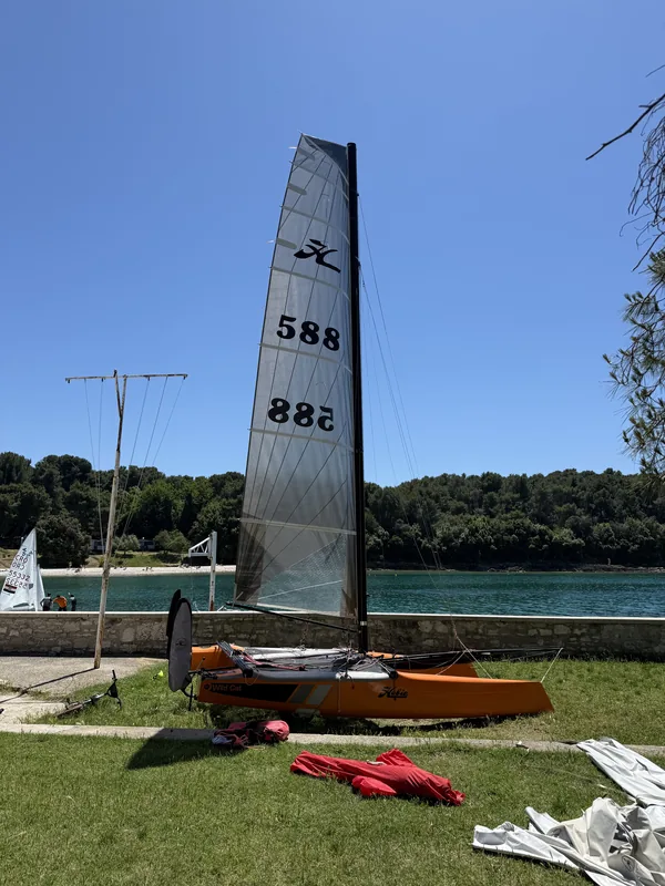 Hobie Wild Cat 588 opremljen na plaži u Puli, visoki jarbol na vedrom nebu.