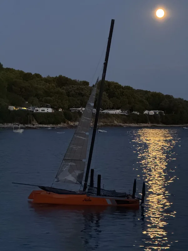 Hobie Wild Cat 588 na sidru pod punim mjesecom, mjesečina se odbija na vodi.